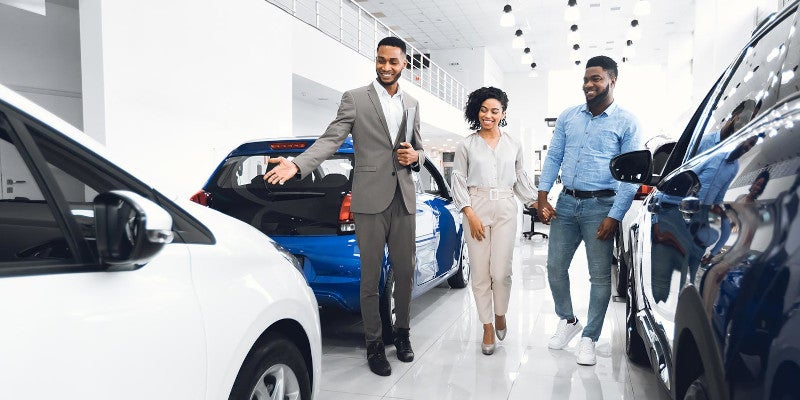 Car salesman showing couple around showroom