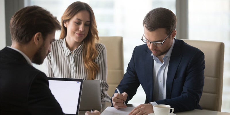 Couple at desk filling out paperwork 