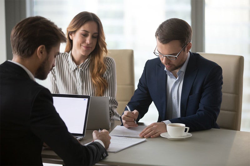 Couple at desk filling out paperwork 