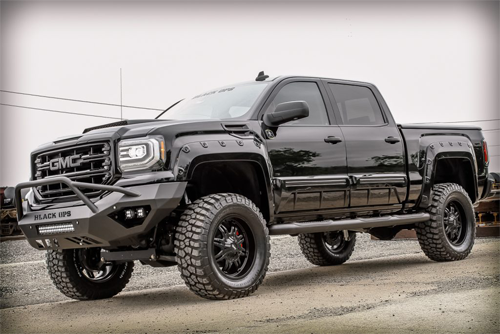 side angle of red GMC lifted truck