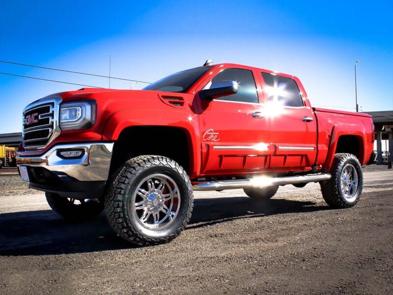 side angle of red GMC lifted truck